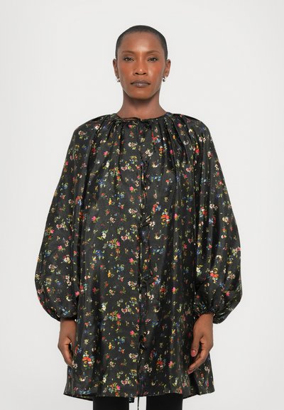 Blouse noire à motifs floraux avec manches bouffantes, en tissu brillant, dotée d'un encolure froncée et de boutons sur le devant.