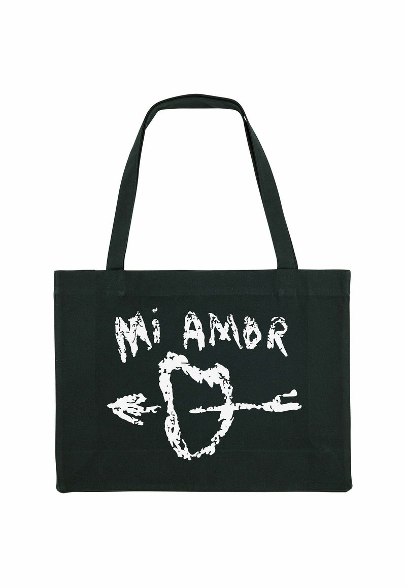 Borsa a tracolla nera in tela con testo bianco disegnato a mano "Mi Amor" e un design di freccia. Manici lunghi e piatti per una facile portabilità.