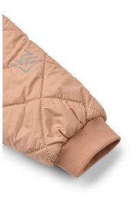 Light pink quilted jacket cuff with ribbed hem, featuring a reflective logo design. Smooth texture with padded sections.
