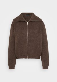 Brun stickad tröja med hög krage och dragkedja framtill. Har ribbade ärmslut och nederkant, vilket ger en strukturerad look.