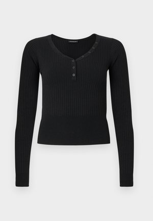 Zwart geribbeld gebreid shirt met lange mouwen, een ronde hals en een gedeeltelijke knoopsluiting met zes knopen aan de linkerkant.