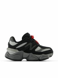 Zwart en grijs sportief schoen met een mesh bovenwerk, dikke rubberen zool, rode accenten en geometrische details aan de zijkanten.