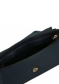 Sac en cuir bleu marine avec une finition texturée, doté d'une fermeture à pression dorée et d'une poche zippée intérieure. Design compact avec des lignes épurées.