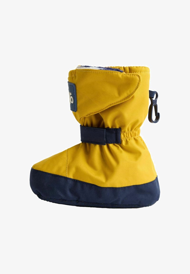 Keltaiset lumisaappaat, joissa on tummansininen alaosa, tiukasti kiristetty yläosa ja säädettävä hihna. Valmistettu pehmeästä, vedenkestävästä materiaalista.