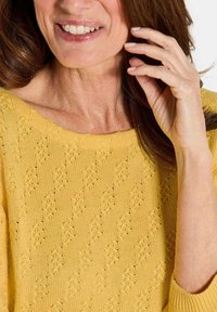 Gelber gestrickter Pullover mit weitem Ausschnitt, strukturiertem Muster und lässiger Passform. Der Stoff hat ein weiches, atmungsaktives Design.