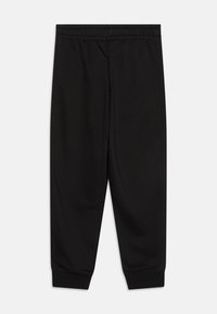 Pantalon de survêtement noir en tissu doux, avec une taille élastique, des chevilles resserrées et un design simple à jambes droites.