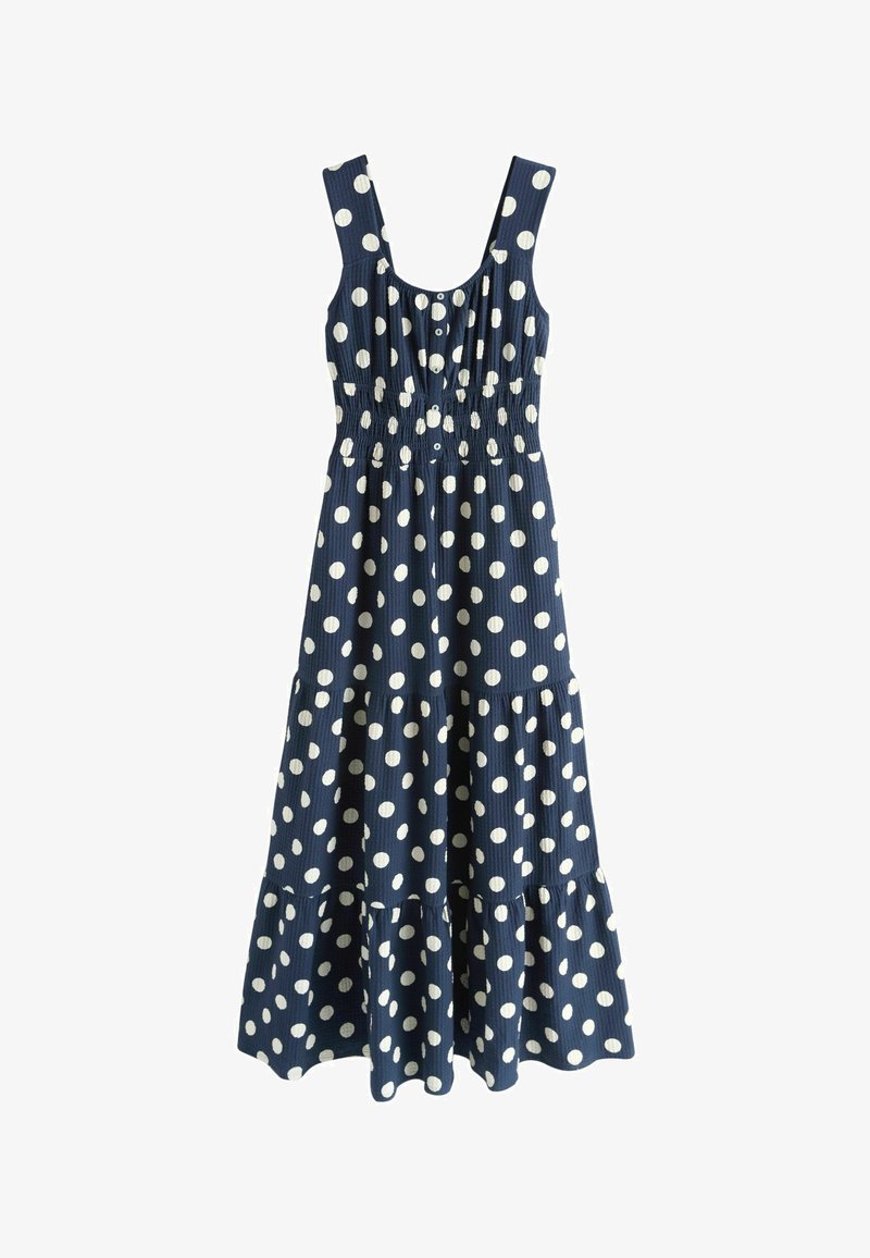 Mouwloze marineblauwe midi-jurk met witte polkadots, knoopsluiting aan de voorkant, getailleerde taille en geplooide rok.