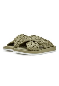 Olijfgroene geweven slippers met een platte zool, voorzien van een dikke gevlochten bovenkant en een witte accent langs de rand van de zool.