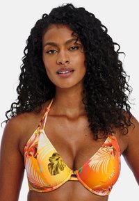 Top de bikini triangulado en naranja con patrones de flores y hojas de palma. Tirantes ajustables y un detalle central de conector. Textura de tela suave.