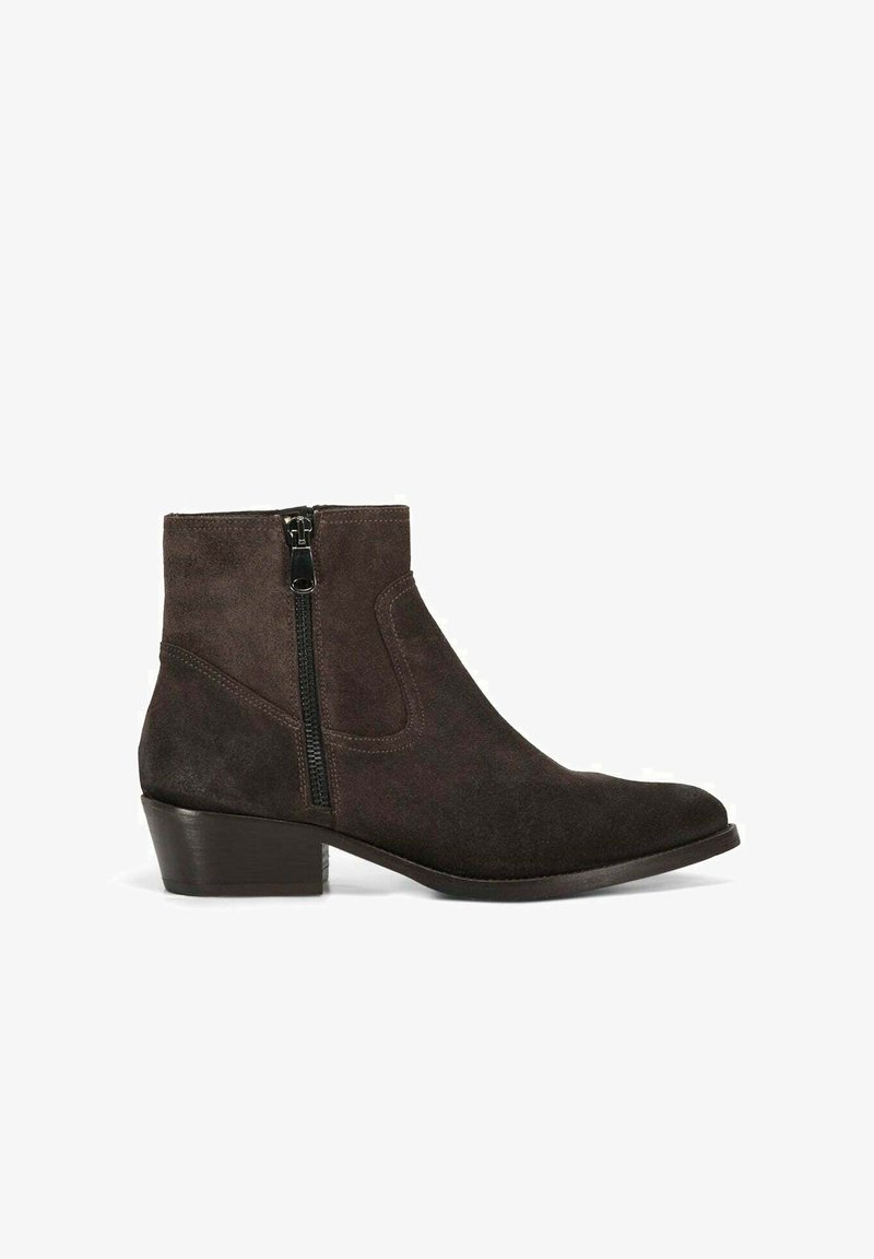 Stivale alla caviglia in suede marrone con tacco a blocco basso, chiusura con zip laterale e texture liscia. Presenta una punta leggermente appuntita e cuciture minime.