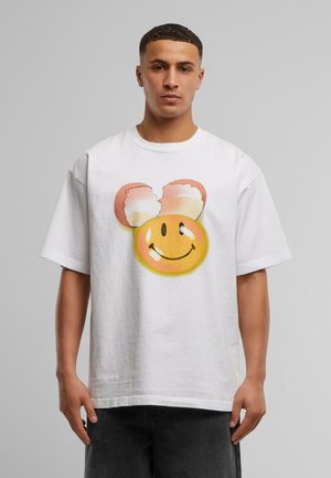 Hvid bomuld t-shirt med et stort, farverigt smiley ansigt grafisk tryk med knækkede isvaffel ører. Løs pasform, kortærmet, enkelt design.