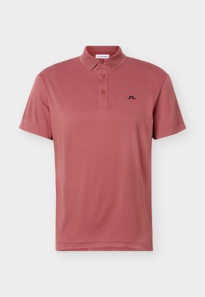 Lühikeste varrukatega tolmurpunane polo-särk, millel on kolm nööpi ja vasakul rinnal väike must logo, lihtsa taustaga.