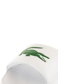 Sandalo bianco a infradito realizzato in materiale sintetico liscio, con logo di coccodrillo verde. Soletta testurizzata per una migliore aderenza, design con punta aperta.