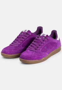 Sneaker in suede viola con un design a profilo basso, caratterizzate da una parte superiore testurizzata, lacci abbinati e una suola in gomma marrone. Accento bianco sul tallone.
