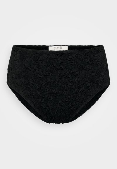 Culotte noire taille haute avec un motif texturé et froissé. La ceinture est élastique et elle a une doublure intérieure lisse.