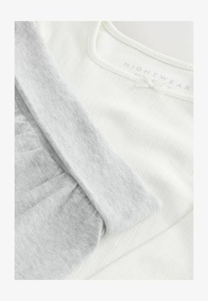 Tissu de nuit blanc avec une texture côtelée, associé à un tissu gris doux. Présente un col rond et des détails froncés. Étiquette visible.
