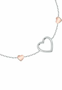 Silberne Halskette mit drei herzförmigen Anhängern: einem hohlen, umrandeten Herz und zwei soliden, pinken Herzen.