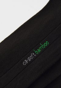 Sosete negre din material de bambus, cu o textură netedă. "ca-soft" în gri și "bamboo" în verde brodate pe lateral.