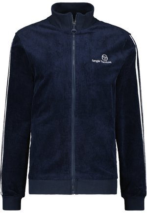 Marineblauwe fluwelen zip-up jas met hoge kraag, witte zijstrepen en een geborduurd logo op de borst. Zachte textuur en aansluitende manchetten.