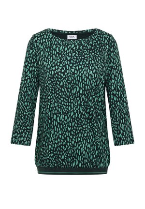 Dames lange mouwen top met een teal en zwarte onregelmatige stippenpatroon, ronde halslijn en een iets elastische onderrand.