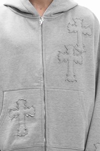Γκρι φούτερ με φερμουάρ κατασκευασμένο από απαλό ύφασμα, με τρία ανάγλυφα σχέδια σταυρών, δύο τοποθετημένα στο μπροστινό μέρος και ένα στην τσέπη.