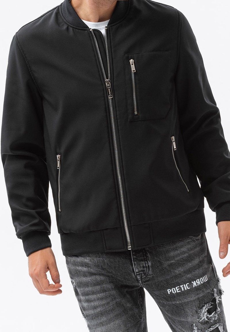 Black bomber jacket with a zippered front, ribbed cuffs, and a chest pocket. Made from smooth fabric with a sleek, minimalist design.