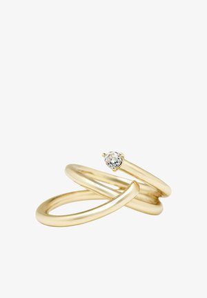 Goldener offener Spiralenring mit einem kleinen runden klaren Edelstein, der an einem Ende vor einem weißen Hintergrund eingesetzt ist.