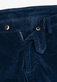 Pantaloni in corduroy blu navy con zip, due bottoni e una superficie testurizzata e striata. Dettagli includono una vita affusolata e cuciture laterali.