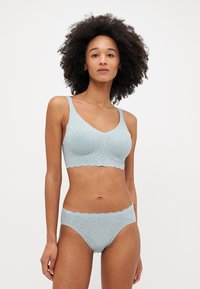 Lichtblauw lingeriesetje van textuurstof, met een V-hals bralette met brede bandjes en bijpassende slip met kantafwerking.