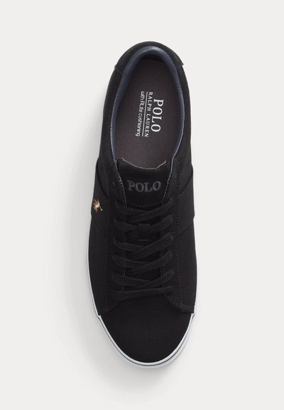 Melns Polo Ralph Lauren zema profila sporta apavu ar baltu zoli, šņorējams priekšpusē un ar Polo logotipu uz mēlītes un iekšējās zolītes.