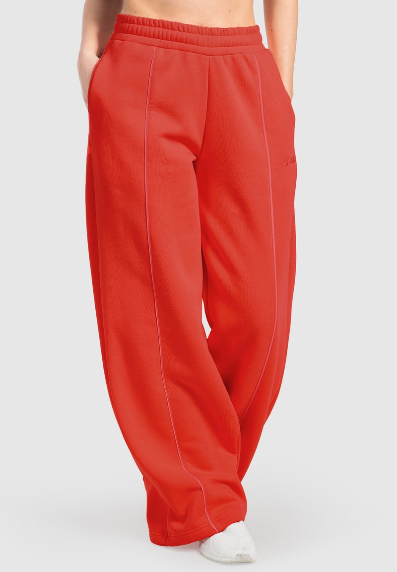 Røde sweatpants med en tekstureret overflade, elastisk talje og to sidelommer. Har kontrasterende lyserød syning og bred ben-design.