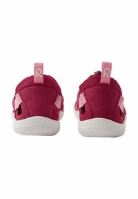 Scarpe da ginnastica rosa con tomaia in rete, cinturini regolabili e suole bianche. Presentano un anello sul tallone per indossarle facilmente.