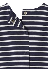 Marineblau-weiß gestreifter Stoff mit offenen silbernen Druckknöpfen entlang des Garmentrands, Nahaufnahme des Ausschnitts und der Verschluss.