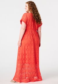 Maxi-jurk in helder koraal met kant, korte mouwen, met een ruitpatroon, tailleband en een vloeiende rok. Gevoeld en semi-doorzichtig.