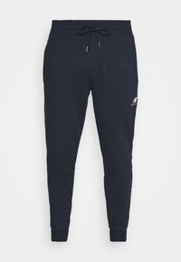 Marineblauwe sweatpants van een zachte katoenmix, met een elastische tailleband met trekkoord, een slim fit en logo-opdruk aan de zijkant.
