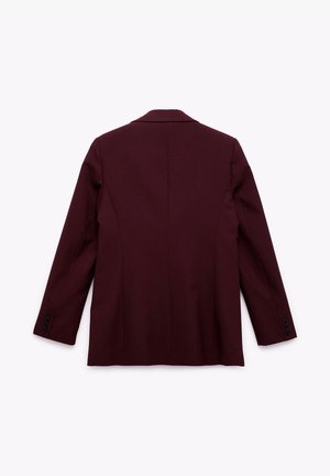Burgundy-tyylinen bleiseri, jossa on sileä kangas, jämäkkä muotoilu, läppäkaulus ja yksinappiset hihansuut. Takana on tyköistuva leikkaus ja sauman yksityiskohdat.
