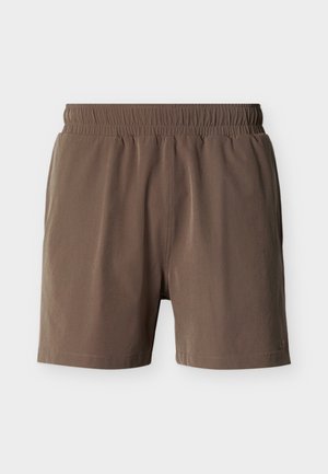 Pantalones cortos marrones con cintura elástica, textura suave y costuras mínimas sobre un fondo blanco liso.