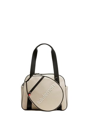 Sac cabas beige et noir avec larges bretelles noires et poche avant arrondie affichant le logo "lululemon" en lettres blanches.