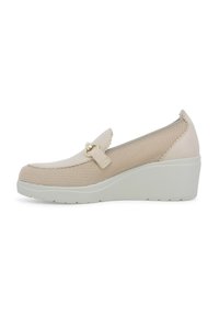 Scarpa con zeppa beige con parte superiore in rete, dettagli in pelle liscia e una tracolla decorativa con elementi in oro. Suola testurizzata per una buona aderenza.