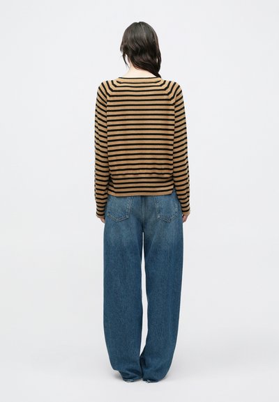 Ριγέ πουλόβερ σε καφέ και μαύρο με λαιμόκοψη καραβίσιο λαιμό; σε συνδυασμό με φαρδιά, ψηλόμεσα μπλε τζιν; απαλό ύφασμα.