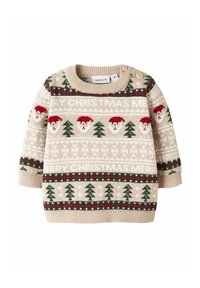 Pull en tricot beige avec des motifs de Noël, comprenant des visages de Père Noël et des arbres verts, rehaussé de détails rouges et blancs, et avec des boutons sur le côté.