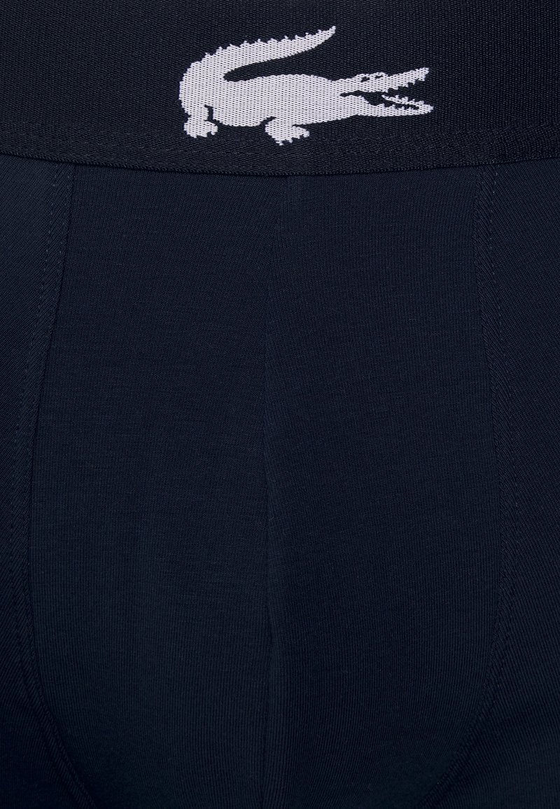 Granatowe bokserki z bawełny, zawierające elastan, z szerokim elastycznym paskiem w talii, ozdobionym białym logo krokodyla Lacoste oraz gładką teksturą.
