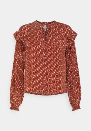 Červená blúzka s viacfarebným geometrickým vzorom, dlhé puff rukávy, gombíkový detail na výstrihu a sukňové manžety. Ľahký materiál.