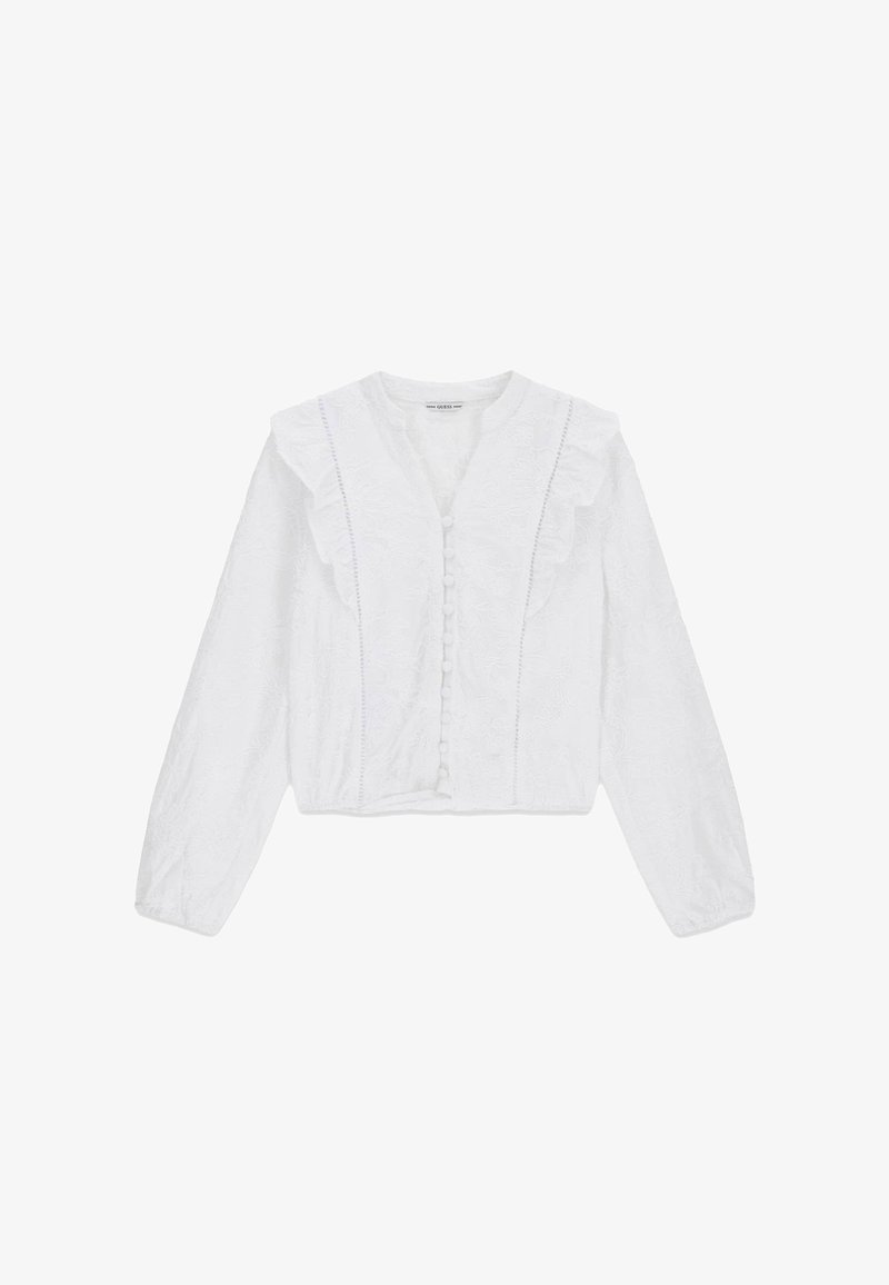 Vit långärmad blus med volangdetaljer, tygknappar framtill och en subtilt blommönsterbroderi.