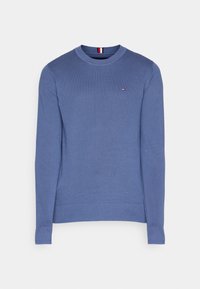 Pull en maille bleu à manches longues avec encolure ronde, poignets et ourlet côtelés, et petit logo rouge, blanc et bleu sur le côté gauche de la poitrine.