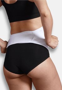 Svarta högmidjade trosor med ett vitt stödjande midjeband. Tyget ser slätt och elastiskt ut, med en rundad design och sömlösa kanter.