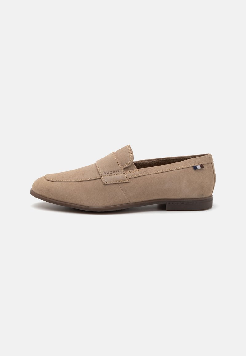 Beige suede loafers with a smooth texture, rounded toe, and a decorative strap. Includes a small logo accent on the heel. Flat sole.