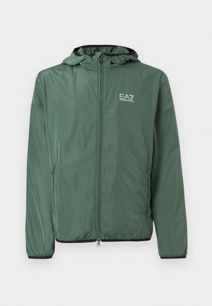 Tmavozelená bunda s kapucňou na zips, so elastickými manžetami a logom "EA7 Emporio Armani" na ľavej strane hrude, zobrazená na bielom pozadí.
