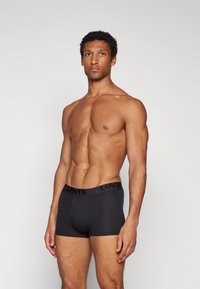 Fekete boxer alsónadrág a Levi's-től, rugalmas pamutból készült, puha derékpánttal, dombornyomott logóval és kényelmes, szoros illeszkedéssel.