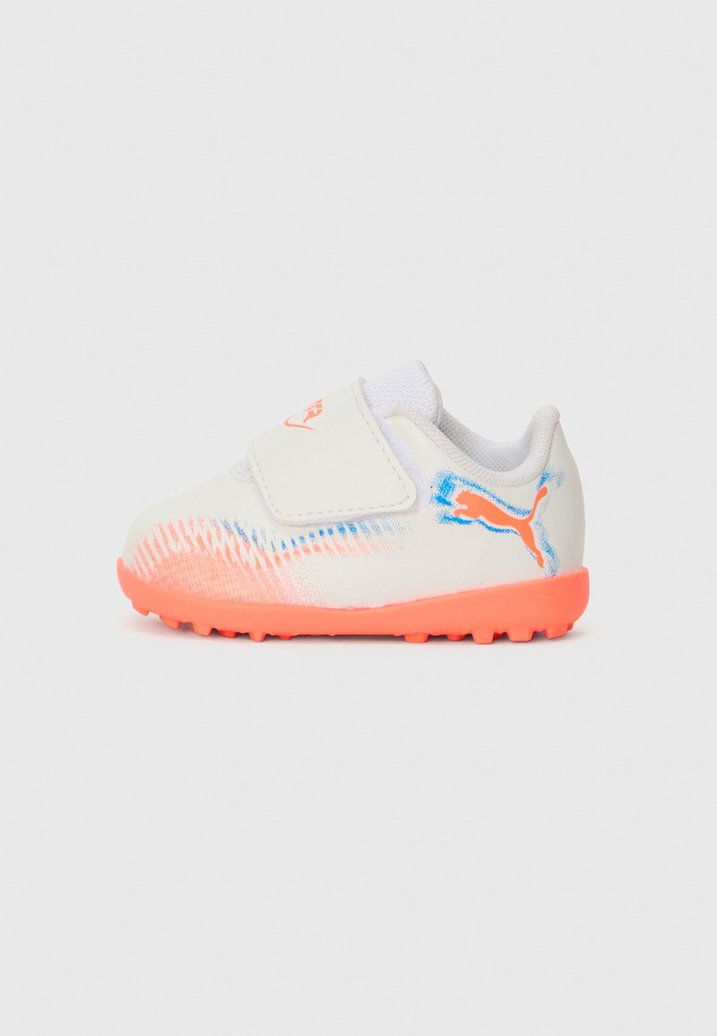 Zapatilla deportiva blanca con una correa de velcro, que presenta acentos en color coral y una suela texturizada para tracción, resaltada con un gráfico azul.